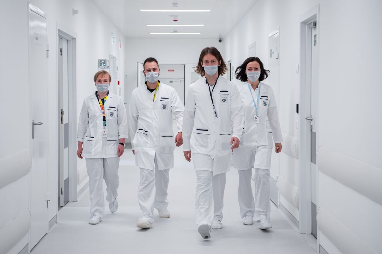 Medical team walking confidently in a hospital corridor, wearing face masks and white coats, symbolizing teamwork and healthcare dedication.